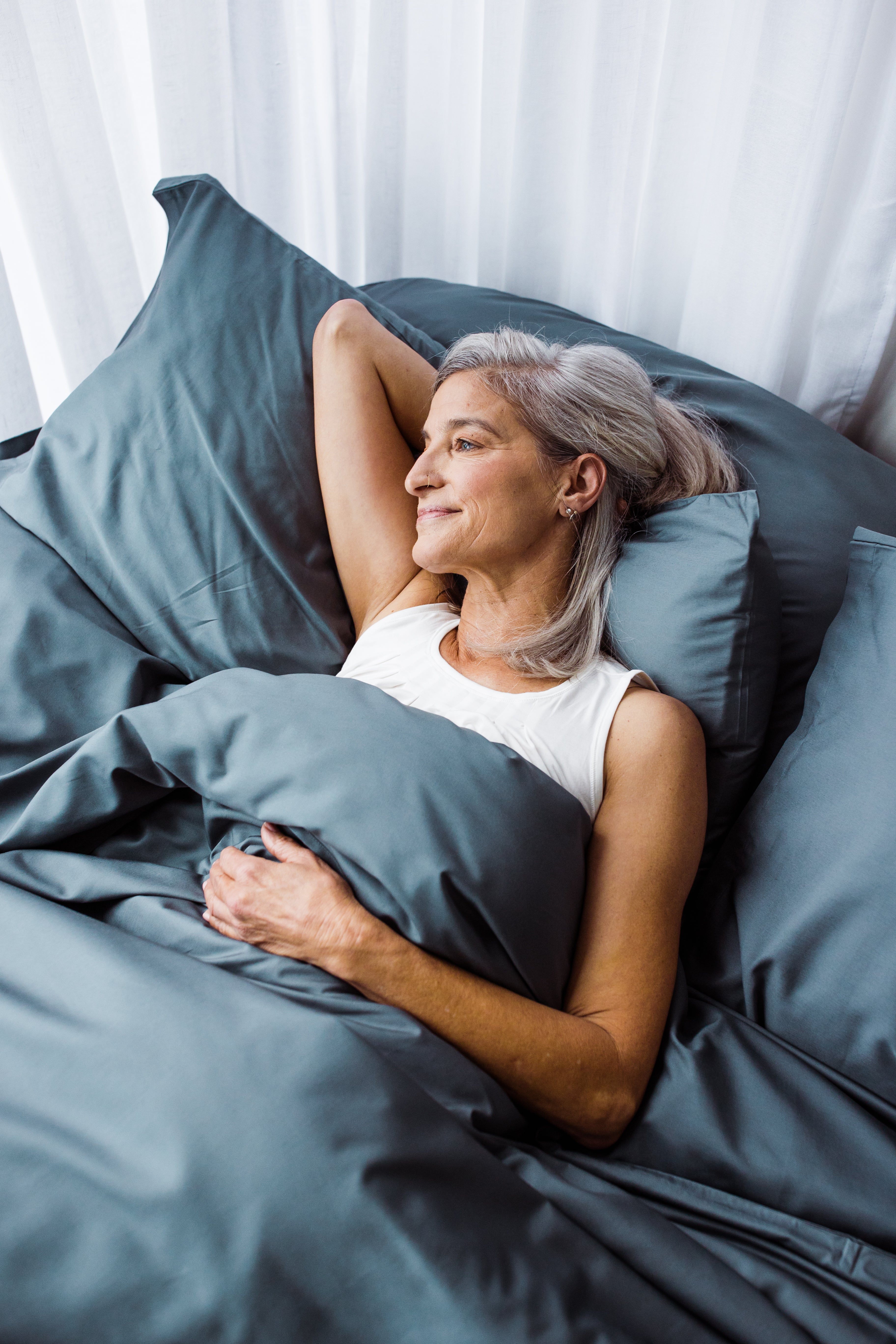 Lady with silver hair enjoys her bedding